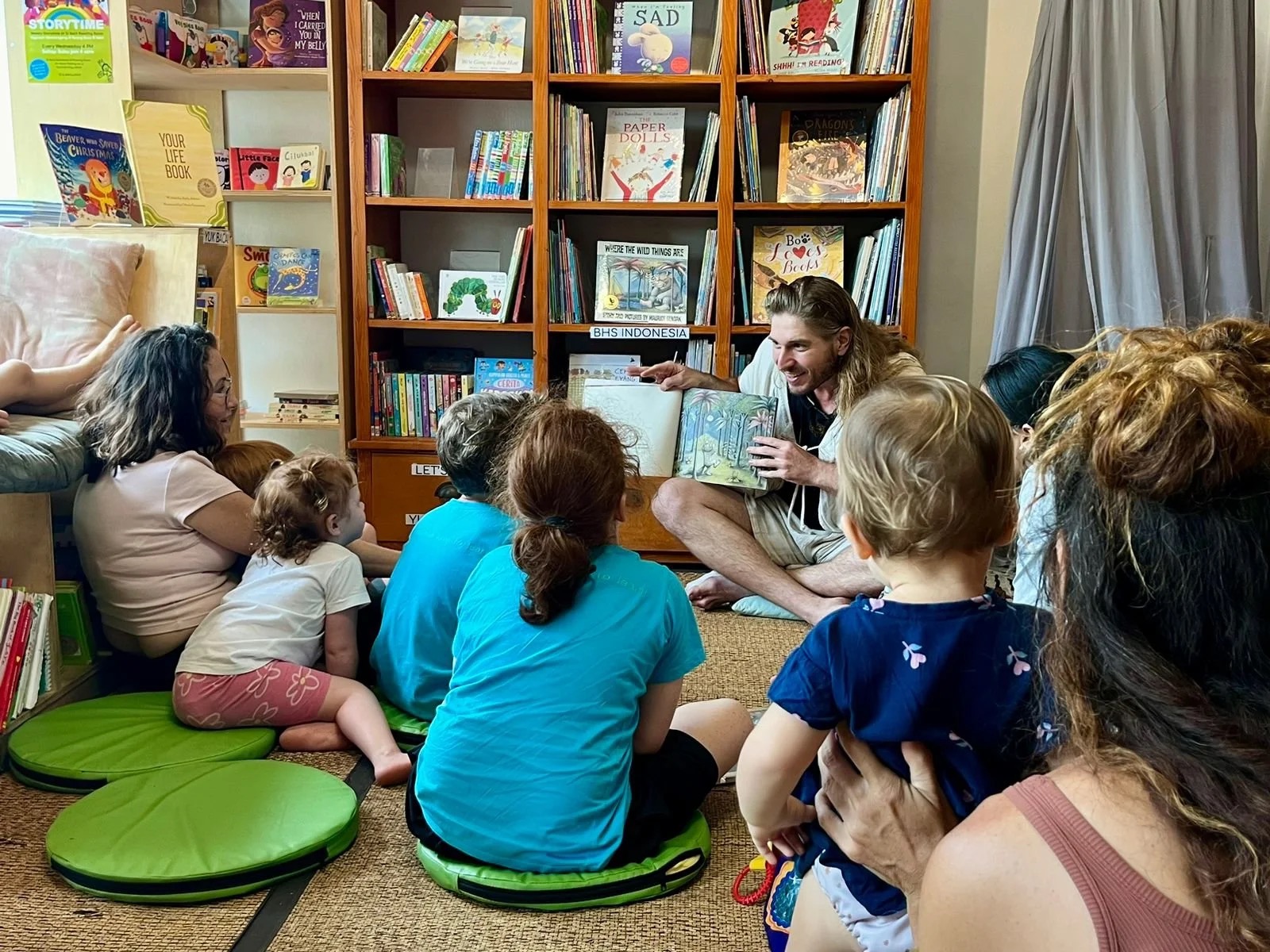 Dr. Julian reading Where the Wild Things Are to children in a cozy bookshop
