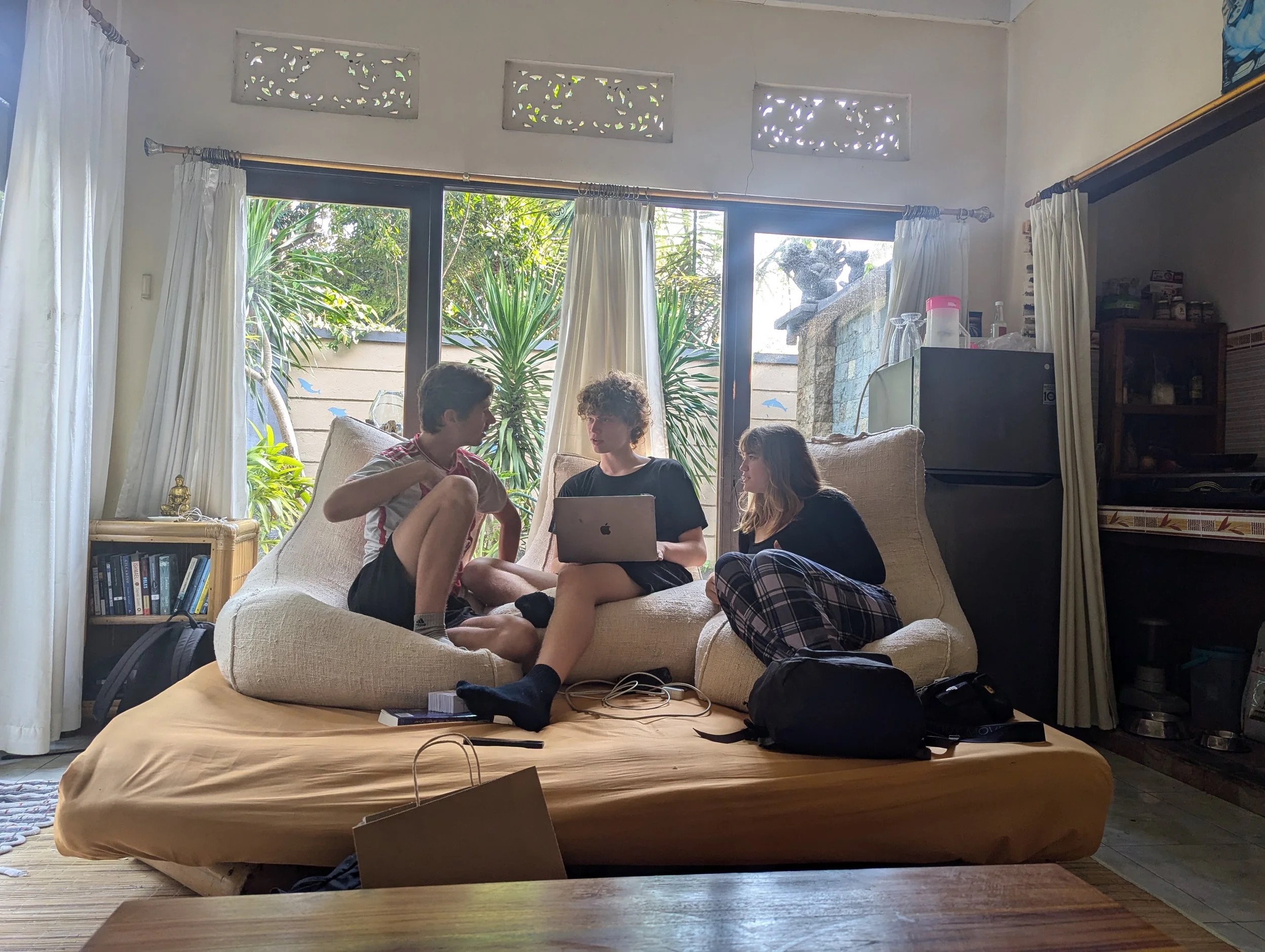 Students collaborating on a MacBook in a Bali villa learning environment